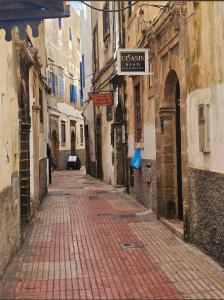 an alley with a brick road in an old building at Dar darkom in Essaouira +8 photos