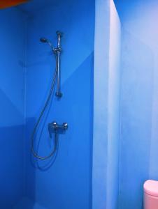 a shower in a blue bathroom with a hose at Dar darkom in Essaouira