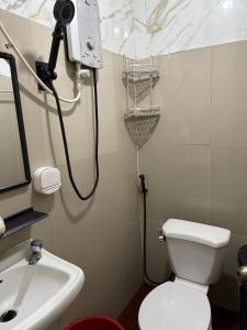 a bathroom with a white toilet and a sink at PrincessStar in Pagadian +16 photos