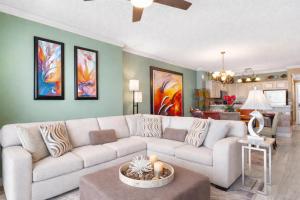 a living room with a white couch and a table at Luxury Beachfront Condo Free Beach Chairs Huge Balcony Come Relax! in Panama City Beach