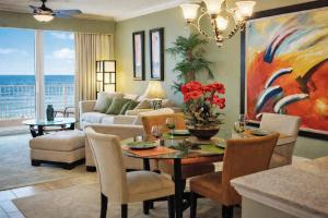 a living room with a table and a painting at Luxury Beachfront Condo Free Beach Chairs Huge Balcony Come Relax! in Panama City Beach