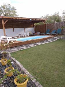 a backyard with a swimming pool with chairs and a pavilion at Haut de Villa HAVA in Anse-Bertrand