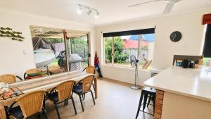 a kitchen and dining room with a table and chairs at The Orchid Courthouse - Busselton in Geographe