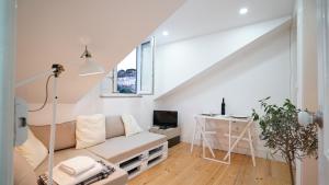a white living room with a couch and a desk at Mouraria Apartments in Lisbon