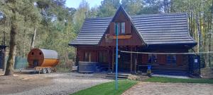 a large wooden cabin with a trailer in front of it at Grubałówka in Rogówko