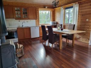 a kitchen with a table and chairs and a stove at Cozy cabin close to nature in Sorreisa