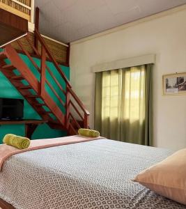 a bedroom with a bed and a wooden staircase at Rainforest Yasmin Hotel in Santa Fé +35 photos