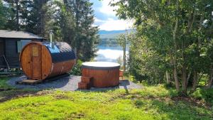 a large wooden barrel next to a cabin with a lake at Cozy cabin close to nature in Sorreisa