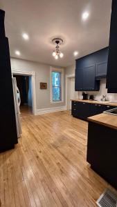 a kitchen with black cabinets and a wooden floor at Maison Jodoin - Suite Albert in Saint-Hyacinthe