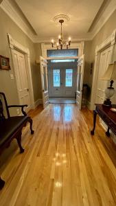 a living room with a wooden floor and a door at Maison Jodoin - Suite Albert in Saint-Hyacinthe