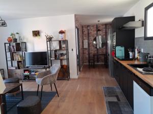 a kitchen and living room with a counter and a television at GITE Mourèzeva in Mourèze