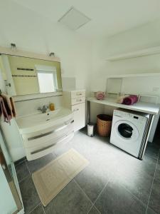 a bathroom with a sink and a washing machine at La Maison du Chenal in Gravelines +38 photos