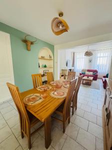 a dining room with a wooden table and chairs at La Maison du Chenal in Gravelines