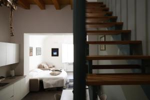 a room with a bed and a spiral staircase at Caudium B&B in Montesarchio