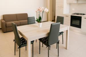 a kitchen and dining room with a wooden table and chairs at Sole e Luna in San Vito