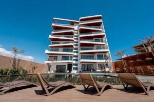 a large apartment building with two chairs in front of it at lunera Immo in Dakan
