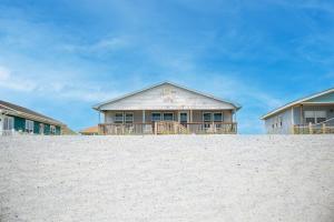 a house sitting on top of a sandy beach at Blue Haven by Oak Island Accommodations in Oak Island