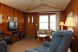 a living room with a couch and a tv at Blue Haven by Oak Island Accommodations in Oak Island