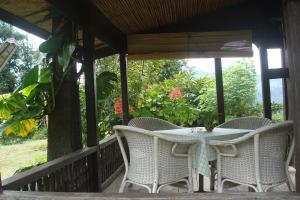 a table and chairs on the porch of a house at Rura Raya Homestay in Rantepao