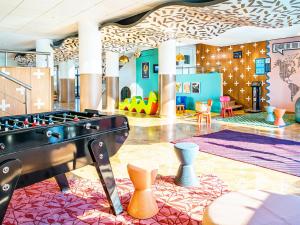 a room with a ping pong table and chairs at Magic Blue Paris à Disneyland in Serris