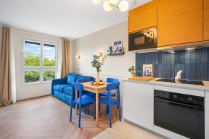 a kitchen with a blue couch and a table at Magic Blue Paris à Disneyland in Serris