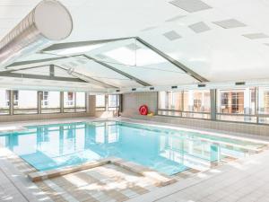 a large swimming pool in a building at Magic Blue Paris à Disneyland in Serris