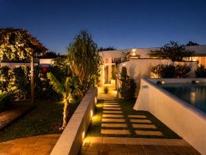 a backyard with a swimming pool at night at Monte da Rocha 3 Marias in São Bartolomeu da Serra