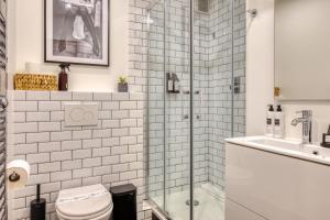 a bathroom with a shower and a toilet and a sink at Paris Central Gem 9 Min Walk to Notre-Dame and Louvre in Paris