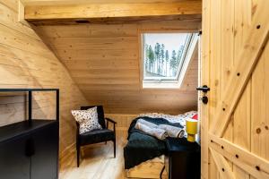 a room with a bed and a window in a wooden room at Kamp Soblówka in Sablówka