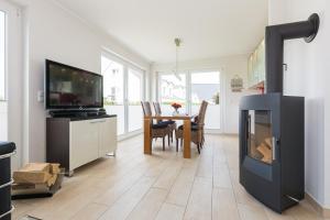a living room with a fireplace and a dining table at FeWo Sanfte Brise im EG mit Blick in die Natur in Göhren-Lebbin