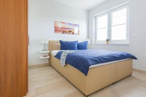 a bedroom with a bed with blue sheets and a window at FeWo Sanfte Brise im EG mit Blick in die Natur in Göhren-Lebbin