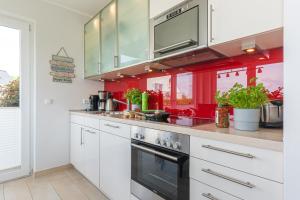 a kitchen with white cabinets and a stove at FeWo Sanfte Brise im EG mit Blick in die Natur in Göhren-Lebbin