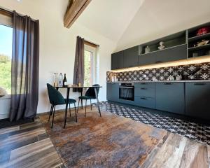 a kitchen with blue cabinets and a table and chairs at Gite Les Petits Monts in Commes +24 photos