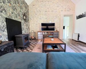 a living room with a couch and a fireplace at Gite Les Petits Monts in Commes