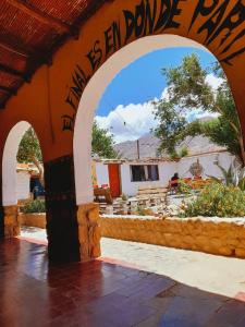 an archway with a house in the background at El Farolo in Tilcara