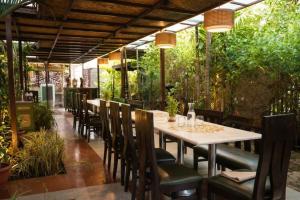 a table and chairs in a restaurant with plants at Swaranjali in Chikhli