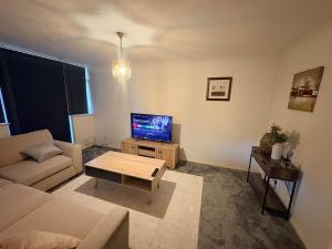 a living room with a couch and a tv at Sycamore haven in Spinney Hill