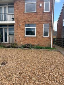 a brick house with white windows and a gravel driveway at Sycamore haven in Spinney Hill
