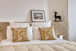 a bedroom with a bed with white sheets and pillows at Paris Central Gem 9 Min Walk to Notre-Dame and Louvre in Paris