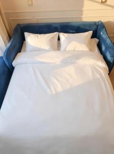 a large bed with white sheets and pillows at Magic Blue Paris à Disneyland in Serris +14 photos