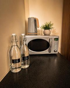 a microwave and two bottles of water on a counter at Stunning City Centre Retreat in Birmingham