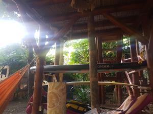 Eine Hängematte in einem Ferienresort mit der Sonne im Hintergrund in der Unterkunft Bongosurfcamp in Mompiche