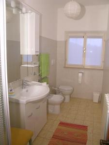a bathroom with a sink and a toilet and a window at L'oleandra appartamenti in Lacona +60 photos