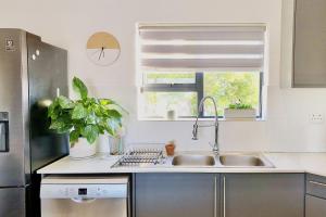 a kitchen with a sink and a window at Cape Winelands Mountain View Getaway in Dalsig +24 photos