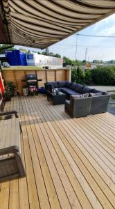 a patio with a couch on a wooden deck at Billet Senior in Fredrikstad
