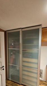 a closet with glass doors in a room at Billet Senior in Fredrikstad