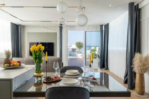 a living room with a dining room table with chairs and a dining room at Dedaj Resort - Penthouse Auri in Zadar