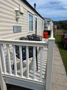 a white deck with two chairs on a house at 613 Promenade, Ingoldmells in Ingoldmells