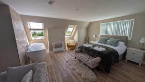 a bedroom with a large bed and a couch at The Wimpey At Mill Cottage in Bedford