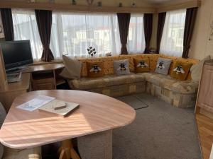 a living room with a couch and a table at 613 Promenade, Ingoldmells in Ingoldmells